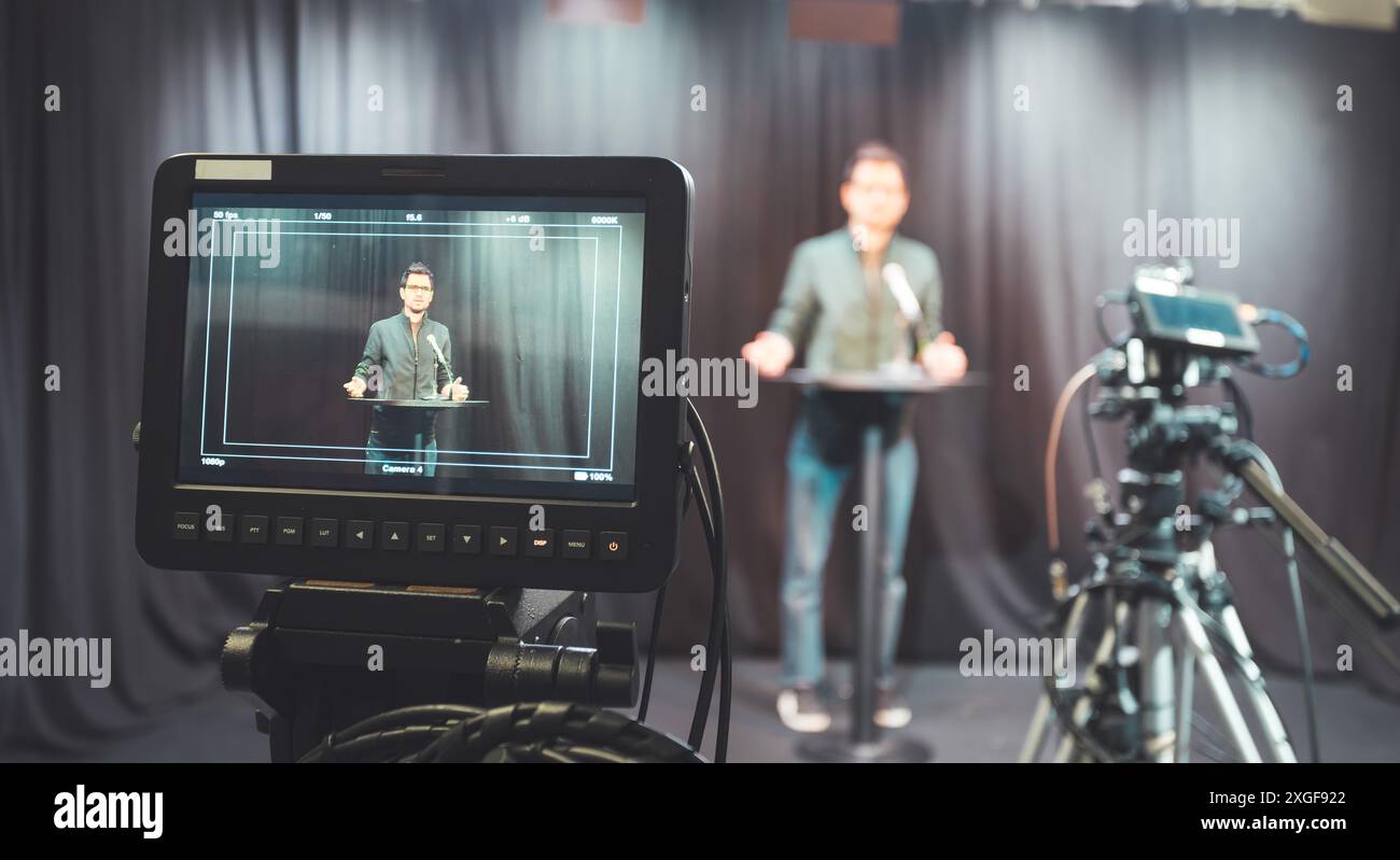 Un journaliste d'un studio de télévision parle dans un microphone, des caméras de cinéma Banque D'Images