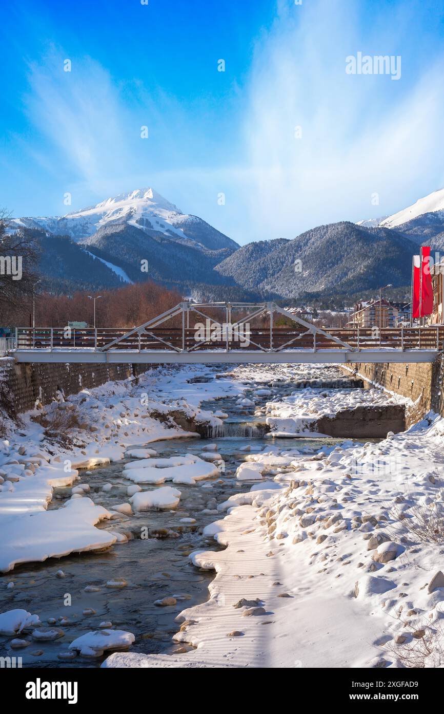 Bansko, Bulgarie, la rivière Glazne dans la ville bulgare et les sommets enneigés des montagnes Pirin Banque D'Images