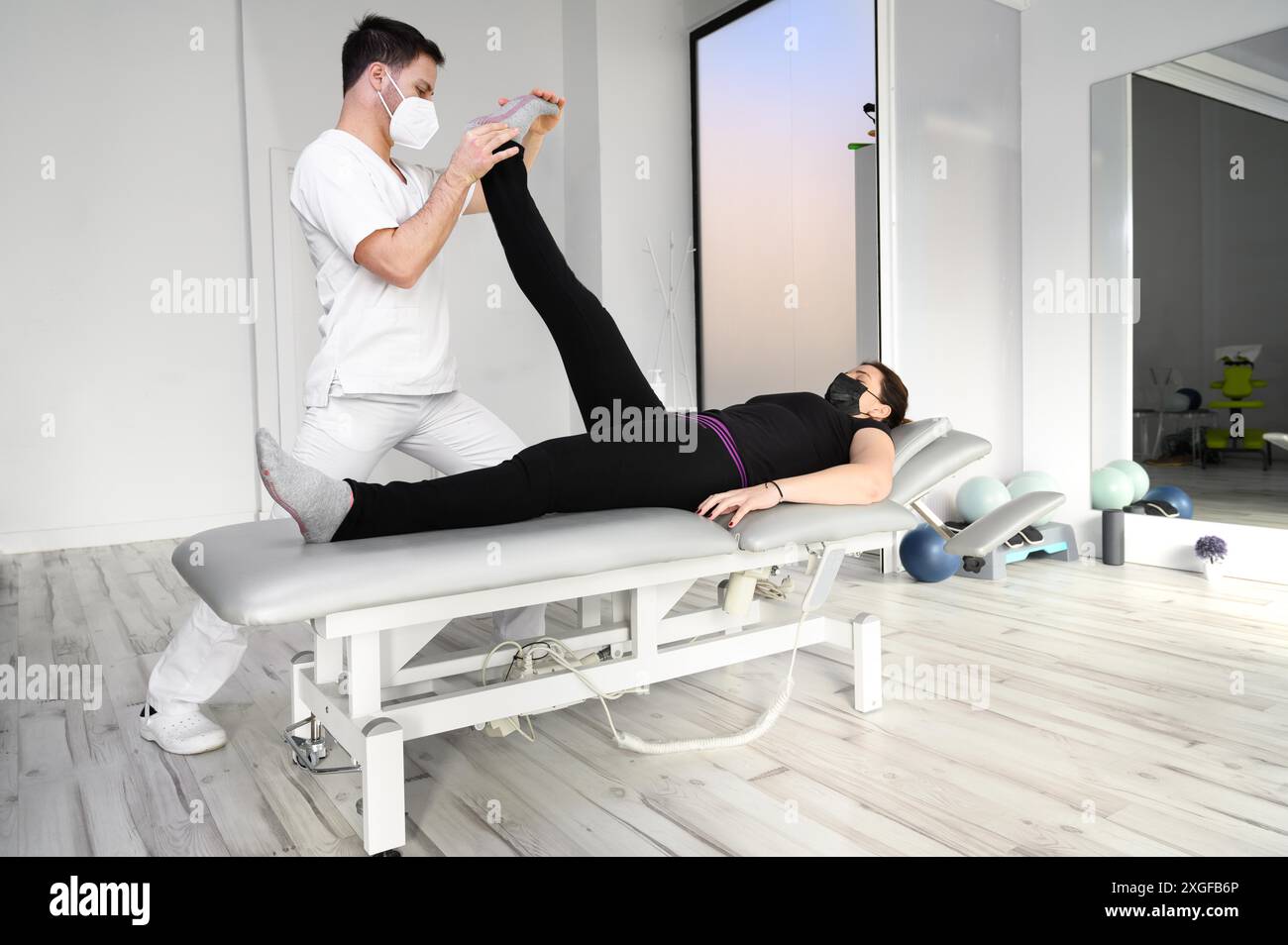 Physiothérapeute faisant des étirements musculaires de jambe chez une patiente. Traitement du nerf sciatique de la femme. Photo de haute qualité Banque D'Images