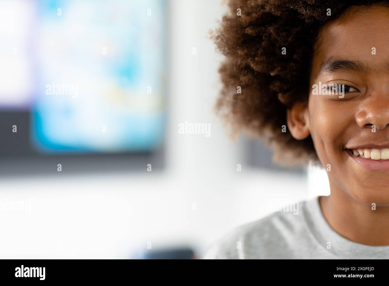 Portrait demi-visage d'écolier afro-américain souriant avec afro, espace de copie Banque D'Images