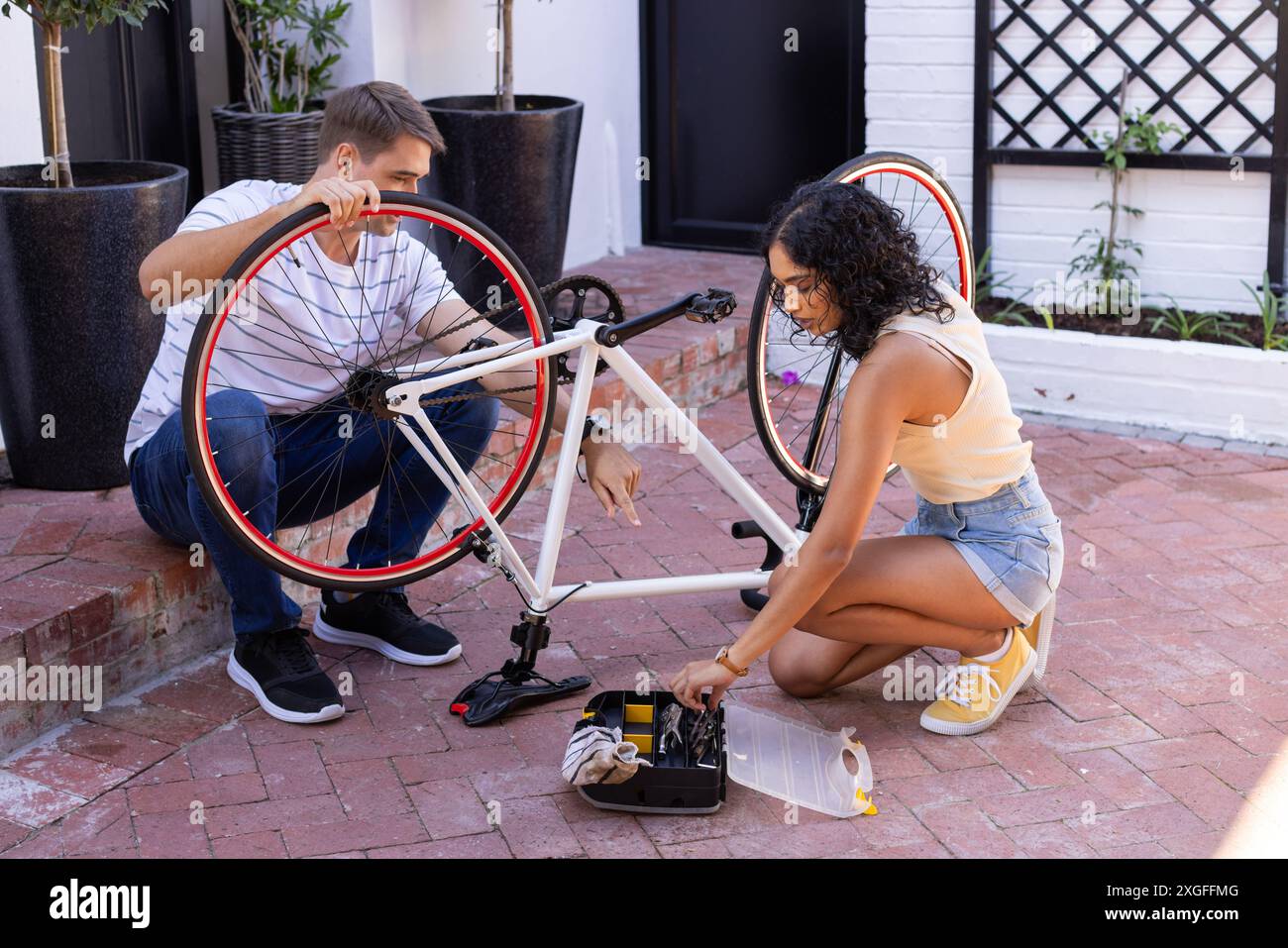 Réparation du vélo, jeune couple travaillant ensemble avec la trousse à outils à l'extérieur Banque D'Images