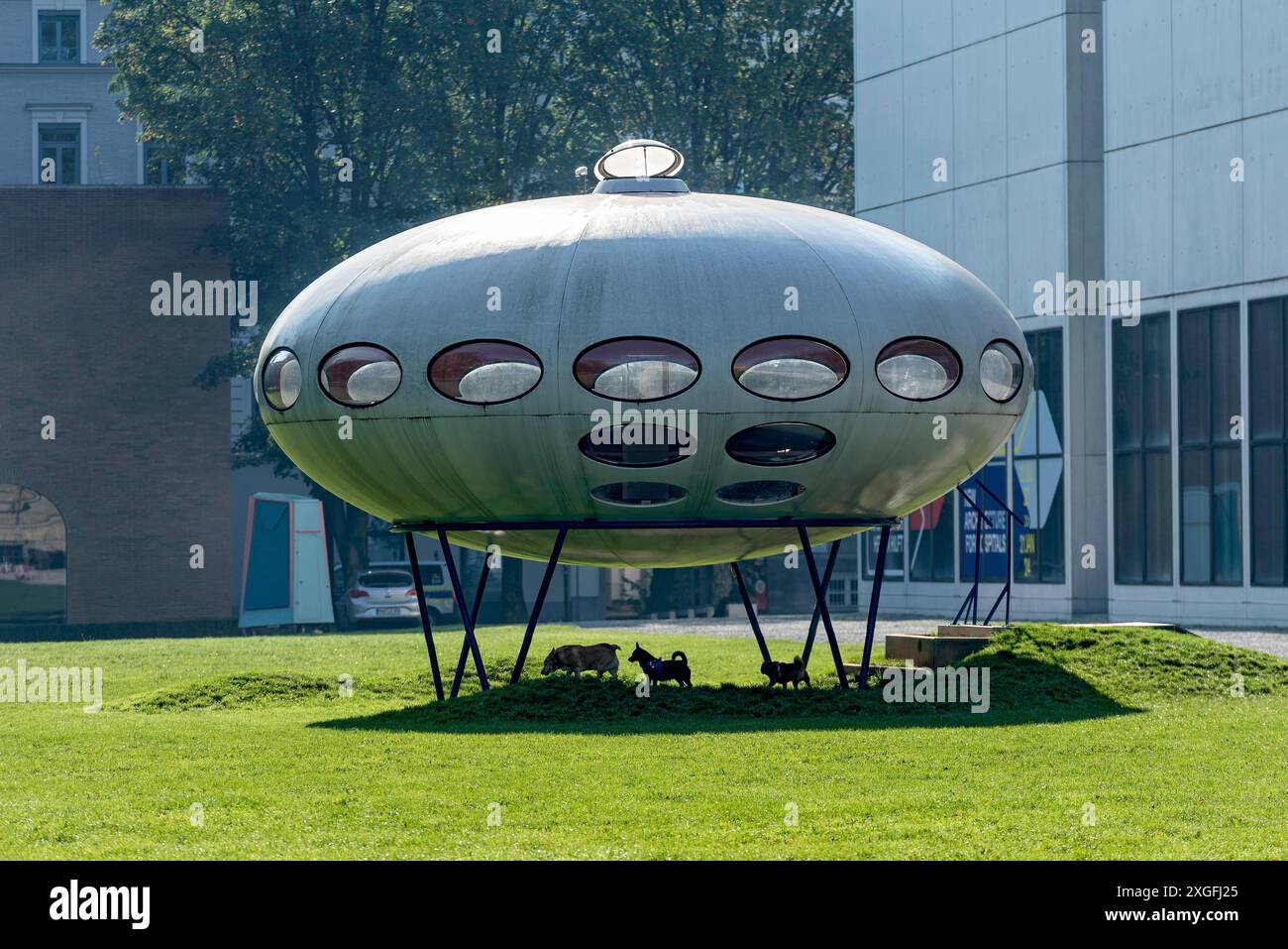 Futuro, Futuro House, maison ronde en plastique par Matti Suuronen, futuriste fonctionnel, OVNI, chiens jouant en dessous, prairie au Musée Pinakothek Banque D'Images