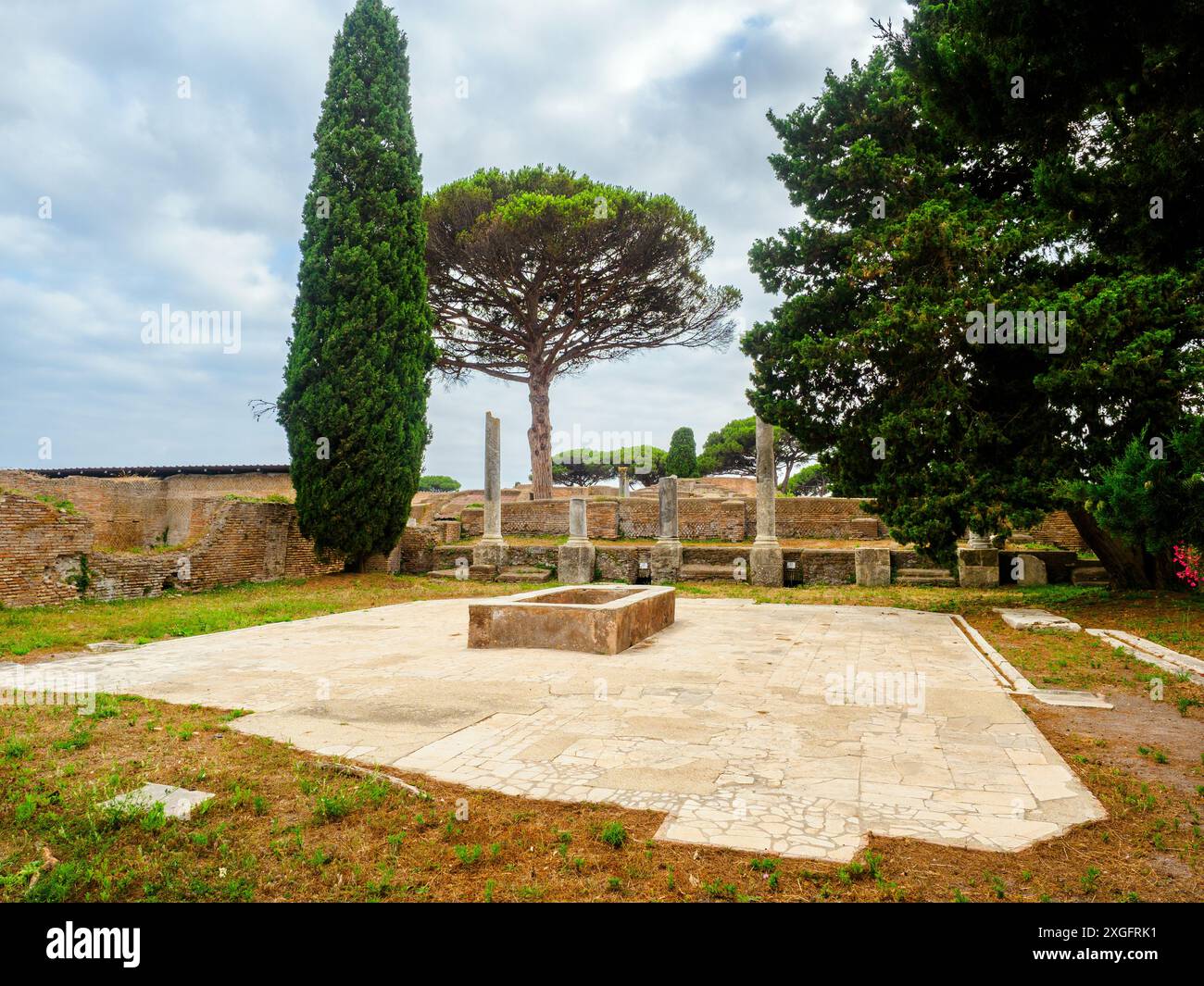 Macellum e Tabernae dei Pescivendoli - le Macellum est accessible depuis le Decumanus par une entrée avec des colonnes sur les côtés de laquelle, dans la première moitié du IIIe siècle après JC, deux tabernae (magasins) ont été créés, dotés de comptoirs pour la vente de poissons et de bassins en marbre. La salle de gauche conserve une mosaïque représentant un dauphin mangeant un calmar, avec l’inscription « Inbide te calco » (« créature envieuse, je te piétinerai »), car on pensait que les dauphins perturbaient la pêche.- Parc archéologique d’Ostie Antica, Rome, Italie Banque D'Images