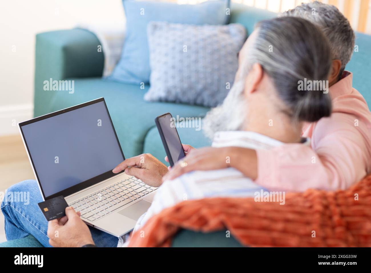 Couple senior utilisant ordinateur portable et smartphone pour les achats en ligne avec carte de crédit, espace copie Banque D'Images Couple senior utilisant ordinateur portable et smartphone pour les achats en ligne avec carte de crédit, espace copie Banque D'Images
