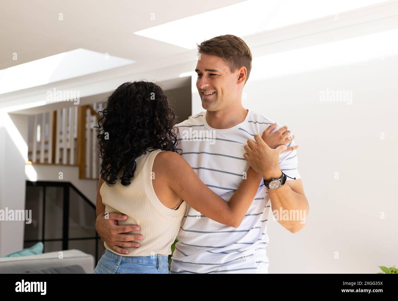 Danser ensemble, jeune couple souriant et profitant du temps à la maison Banque D'Images