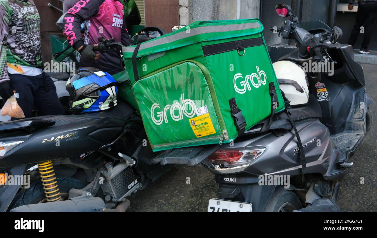 Une boîte de livraison Grob verte est sur le dessus d'une moto Banque D'Images