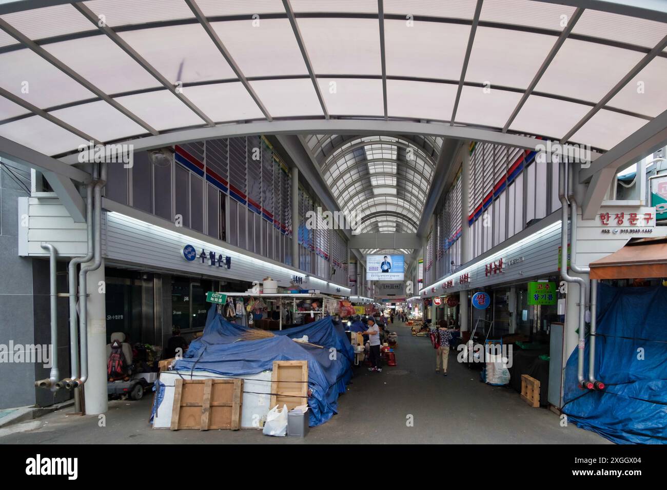 Intérieur d'un marché couvert avec plafond voûté et stands, mettant en valeur le commerce traditionnel coréen Banque D'Images