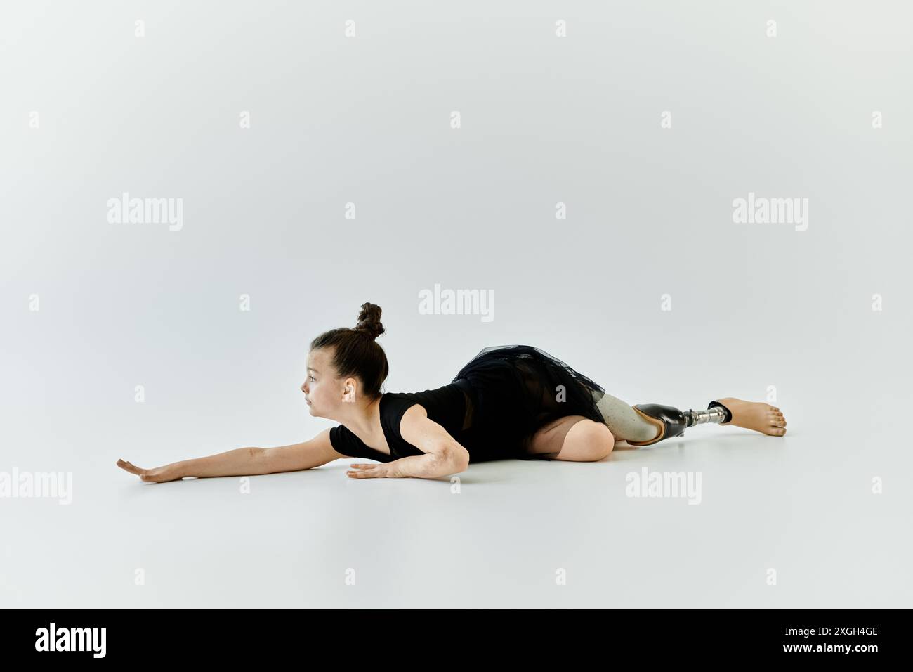 Une jeune fille avec une jambe prothétique effectue un exercice de gymnastique avec force et grâce. Banque D'Images