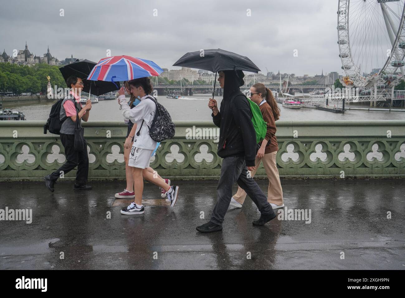 Londres, Royaume-Uni. 9 juillet 2024 . Piétons sur Westminster Bridge avec des parapluies pendant de fortes pluies que le temps humide de l'été continue. Un avertissement de mauvais temps a été émis car de fortes pluies entraîneront des inondations et des perturbations dans les transports dans certaines parties du Royaume-Uni. Credit : Amer Ghazzal/Alamy Live News Banque D'Images