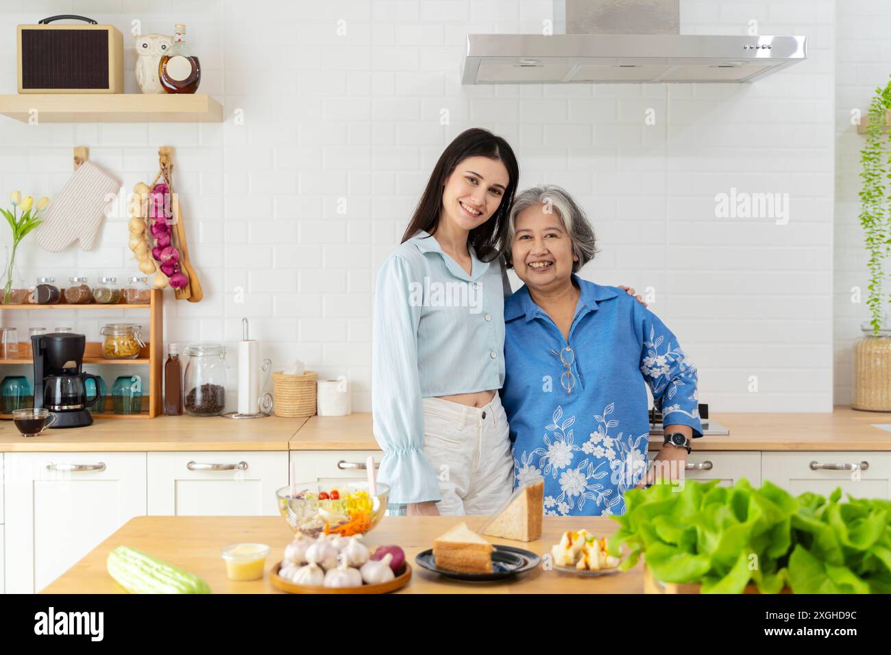 Famille heureuse dans la cuisine. Mère et sa fille adulte préparent un repas approprié. mère et fille, mère et fille embrassant à l'amour sur la mitaine Banque D'Images