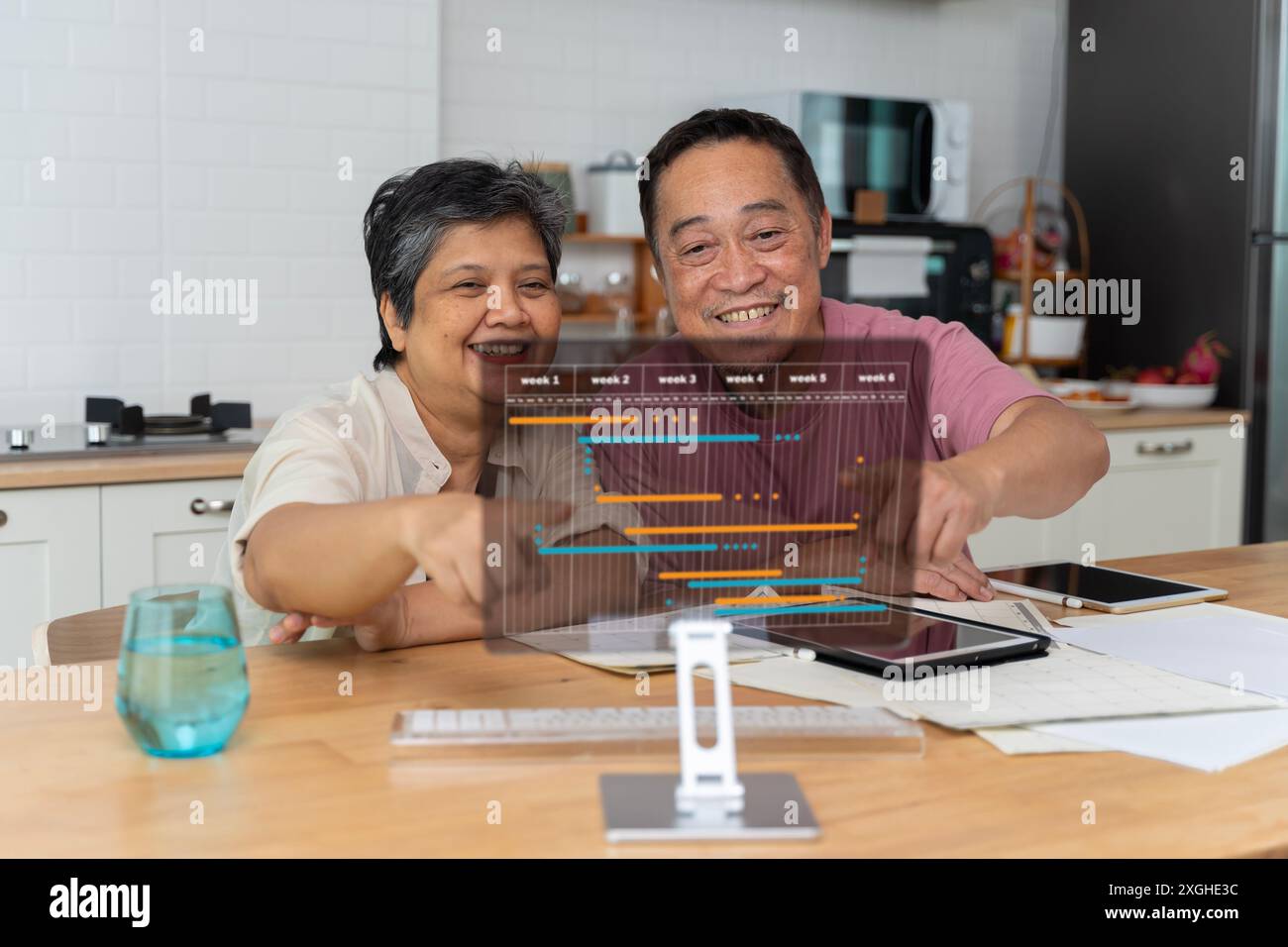 Très heureux de quitter le couple marié d'âge moyen faire un haut cinq, finissant la paperasse domestique ensemble à la maison. Heureux heureux heureux couple marié plus âgé cel Banque D'Images