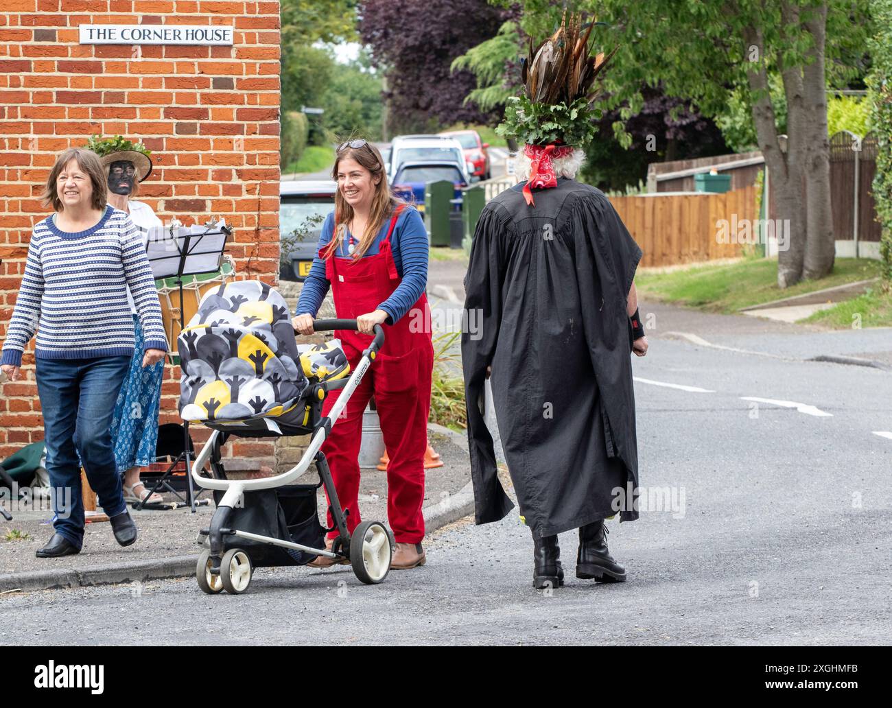 Le chef du Rendham Mummers Suffolk en face noire traditionnelle et tenant une torche flamboyante se produisant sur la route pour le solstice d'été Banque D'Images