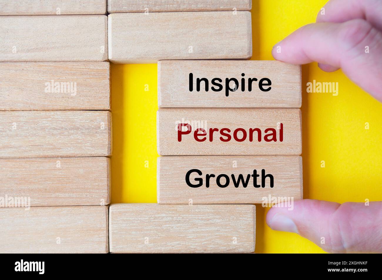 Main tirant des blocs de bois avec le texte inspire Personal Growth sur des blocs de bois. concept inspirant. Banque D'Images
