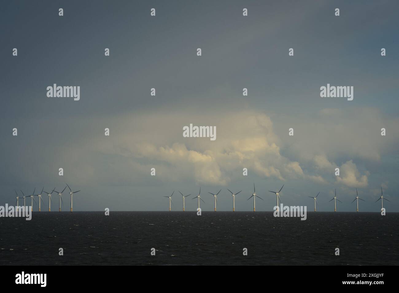 Vue du parc éolien offshore de Gunfleet Sands contre un ciel orageux pris de la rive de Clacton sur la mer, Essex, Royaume-Uni. Banque D'Images