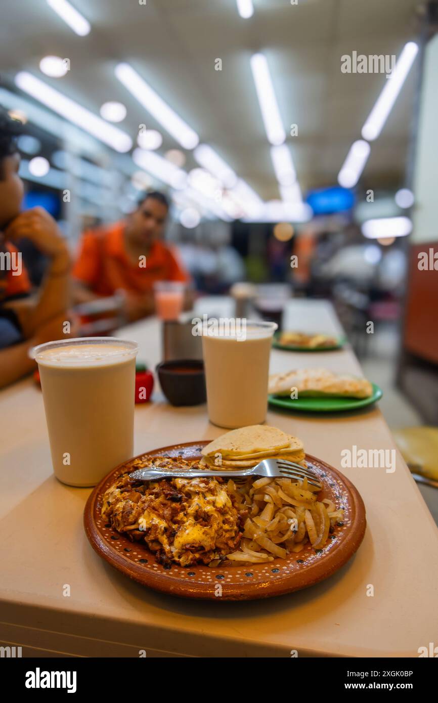 Délicieux alambre avec carne al Pastor, servi avec des tortillas et horchata rafraîchissante, capturé dans un confortable taquería mexicain. Parfait pour mettre en valeur tra Banque D'Images