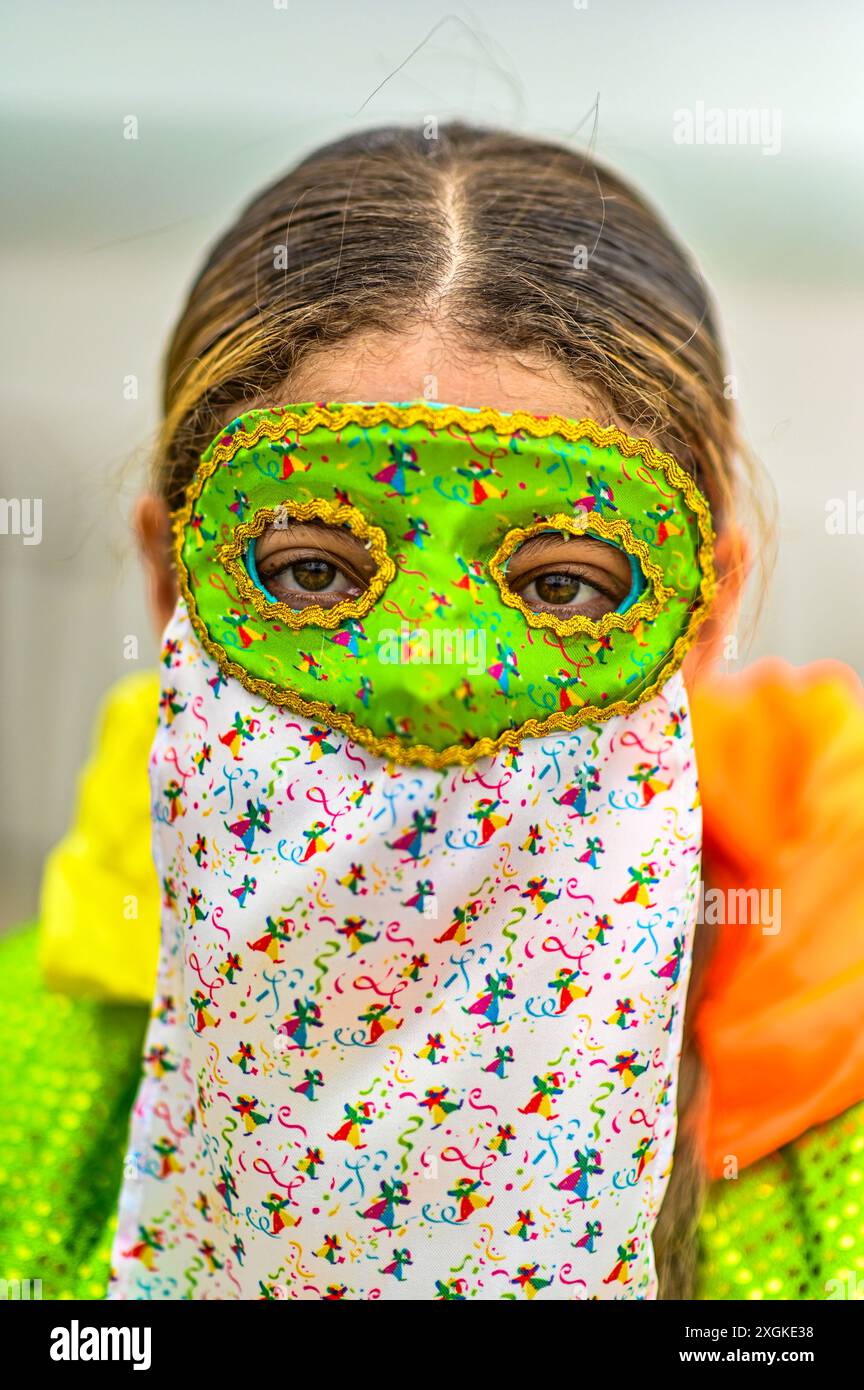 Un Monocuco traditionnel du Carnaval de Barranquilla se tient fièrement dans sa tenue colorée, avec un masque, une cape et un chapeau. Ce costume emblématique symbolise l’esprit ludique et espiègle du festival, avec ses origines ancrées dans la tradition des personnages masqués qui s’engagent avec la foule. Banque D'Images