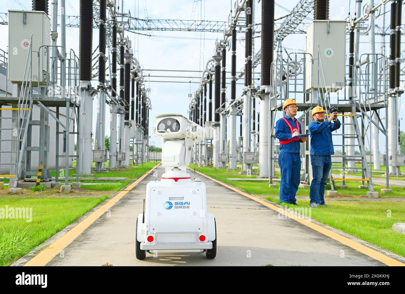 CHUZHOU, CHINE - 9 JUILLET 2024 - Un robot intelligent 5G et le personnel d'exploitation et de maintenance effectuent une inspection spéciale de l'alimentation électrique Equi Banque D'Images