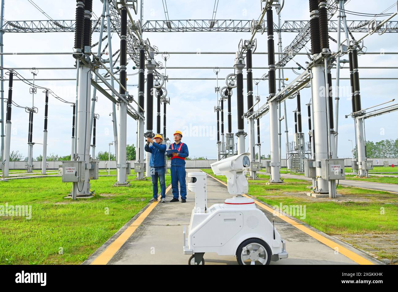CHUZHOU, CHINE - 9 JUILLET 2024 - Un robot intelligent 5G et le personnel d'exploitation et de maintenance effectuent une inspection spéciale de l'alimentation électrique Equi Banque D'Images