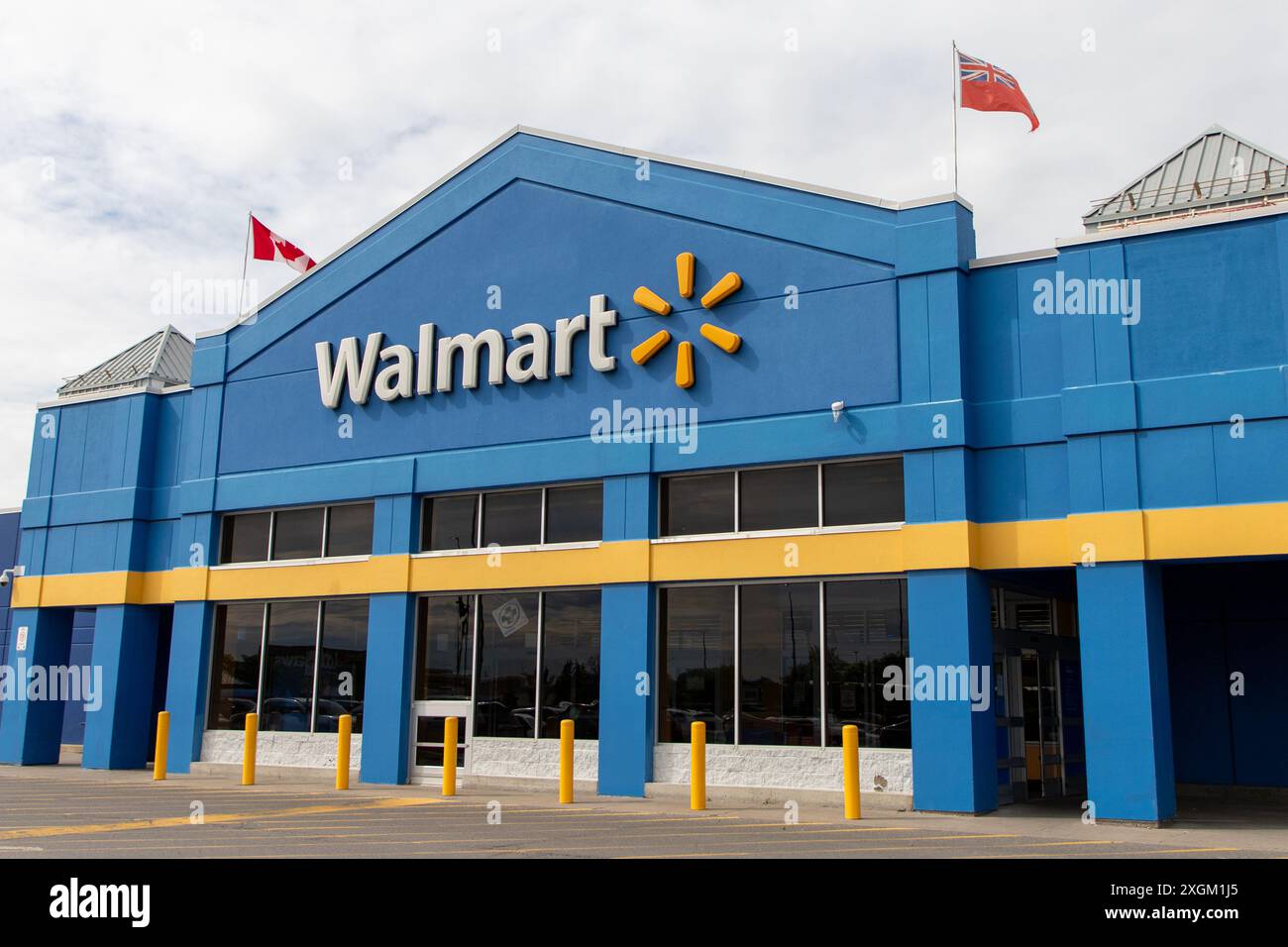 Kanata, Canada - 2 juin 2024 : immeuble de magasins de détail Walmart avec drapeaux canadiens et ontariens Banque D'Images