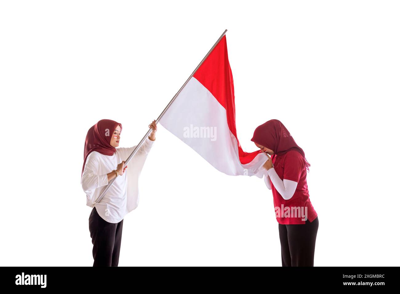 Portrait d'une femme tenant le drapeau indonésien et l'embrassant comme un symbole de fierté du jour de l'indépendance de l'Indonésie isolé sur fond blanc Banque D'Images