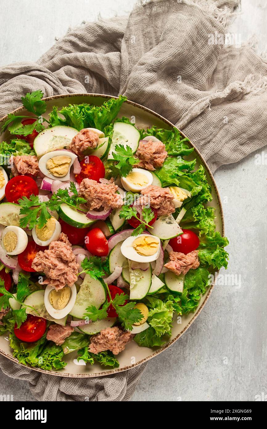 Salade de thon, salade de légumes avec œufs de caille, laitue, oignon rouge et concombres, sur une table gris clair, céto-nourriture, style de vie, alimentation saine, sélective Banque D'Images