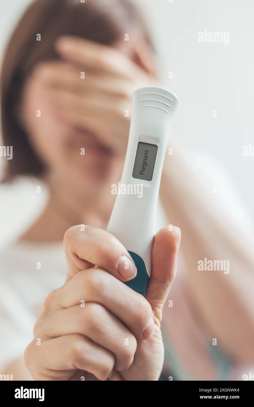 Mère nerveuse tenant le test de grossesse dans ses mains, le résultat est enceinte, ?Pregnant? Banque D'Images