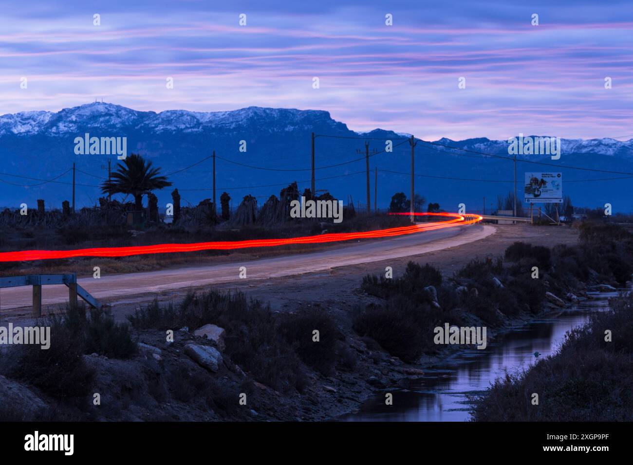 Route de campagne dans le delta de l'Èbre, feux arrière rouges d'une voiture, Catalogne, Espagne Banque D'Images