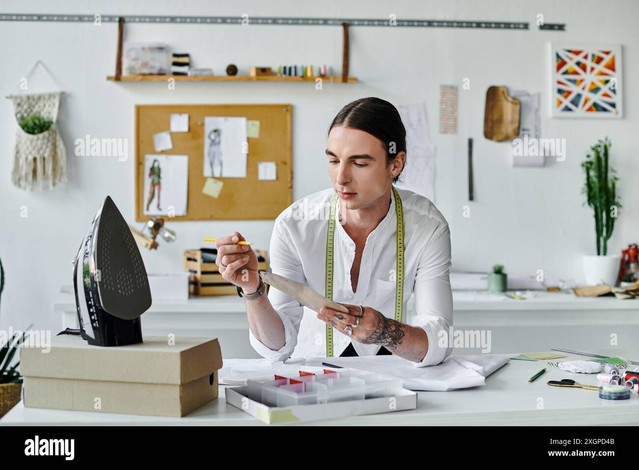 Un jeune homme examine méticuleusement un morceau de tissu, prêt à le transformer en quelque chose de nouveau dans son atelier de restauration de vêtements durables. Banque D'Images