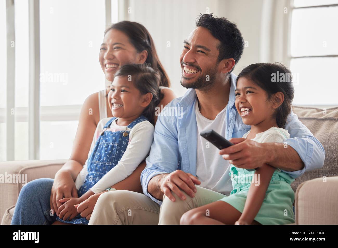 Parents, fille et enfants pour regarder la télévision sur le canapé avec télécommande, câlin et heureux pour le spectacle dans la maison de famille. Père, mère et fille enfants avec Banque D'Images