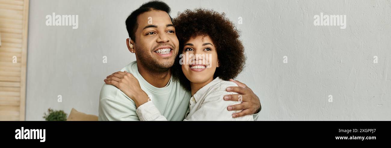 Un couple afro-américain utilise la langue des signes pour communiquer assis à la maison. Banque D'Images