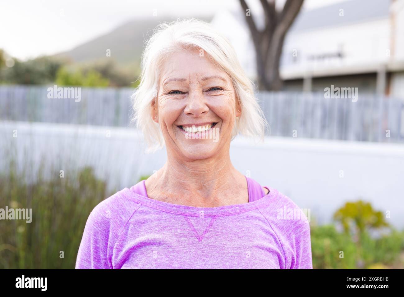 Portrait de femme caucasienne senior heureuse avec les cheveux blancs souriant à l'extérieur. Bien-être, santé et mode de vie actif des aînés, inaltérés. Banque D'Images