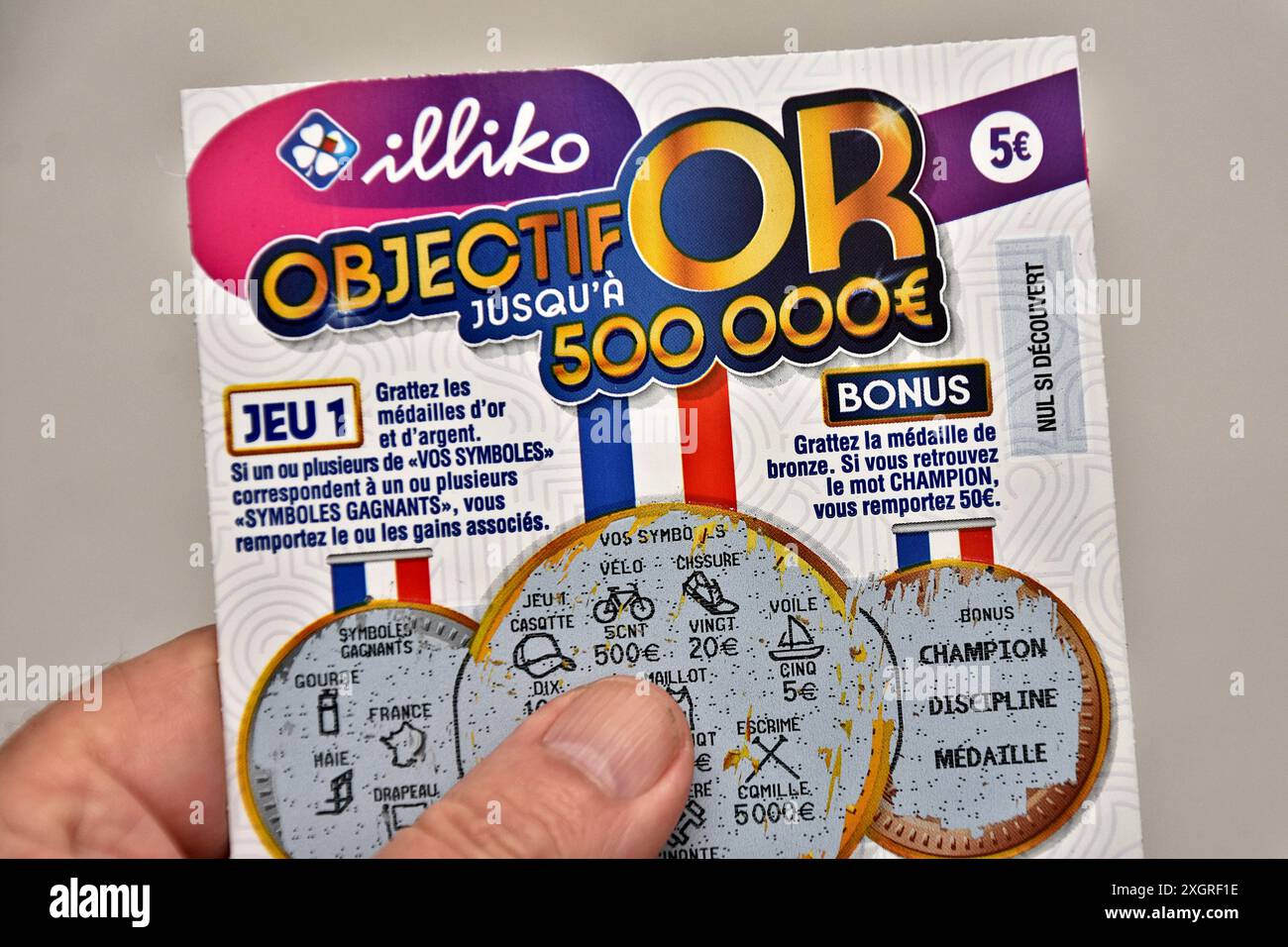 France. 10 juillet 2024. Dans cette illustration photo, un homme tient dans sa main un billet gagnant de 50 euros du jeu objectif ou Scratch. Objectif Or est un nouveau jeu de scratch proposé par la française des Jeux (FDJ) pour les Jeux Olympiques de Paris 2024. Vendu pour 5 euros, il permet aux chanceux d’empocher un gain allant jusqu’à 500 000 euros. (Photo Gerard Bottino/SOPA images/SIPA USA) *** strictement à des fins d'actualités éditoriales *** crédit : SIPA USA/Alamy Live News Banque D'Images