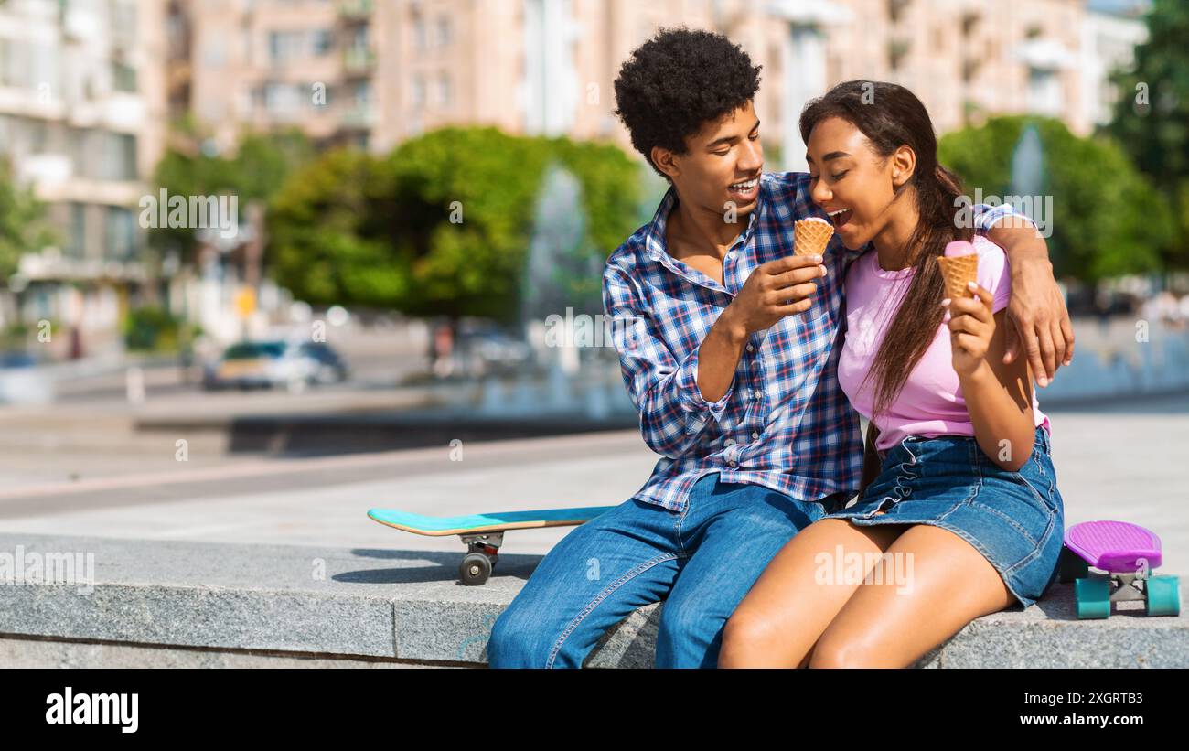 Couple d'adolescents appréciant la crème glacée dans la ville Banque D'Images