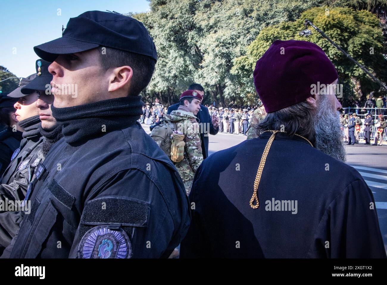Buenos Aires, Argentine. 09 juillet 2024. Un policier regarde la foule qui est venue assister à la parade du jour de l’indépendance, tandis qu’un ecclésiastique de l’Église orthodoxe russe regarde passer les groupes militaires. Dans la ville de Buenos Aires, vers 11h00, le défilé du 9 juillet, jour de la déclaration de l'indépendance de la République Argentine, a eu lieu. L'acte a été présidé par le Président Javier Milei, accompagné de ses principaux responsables. Les vétérans de la guerre des Malvinas menaient le défilé. Crédit : SOPA images Limited/Alamy Live News Banque D'Images