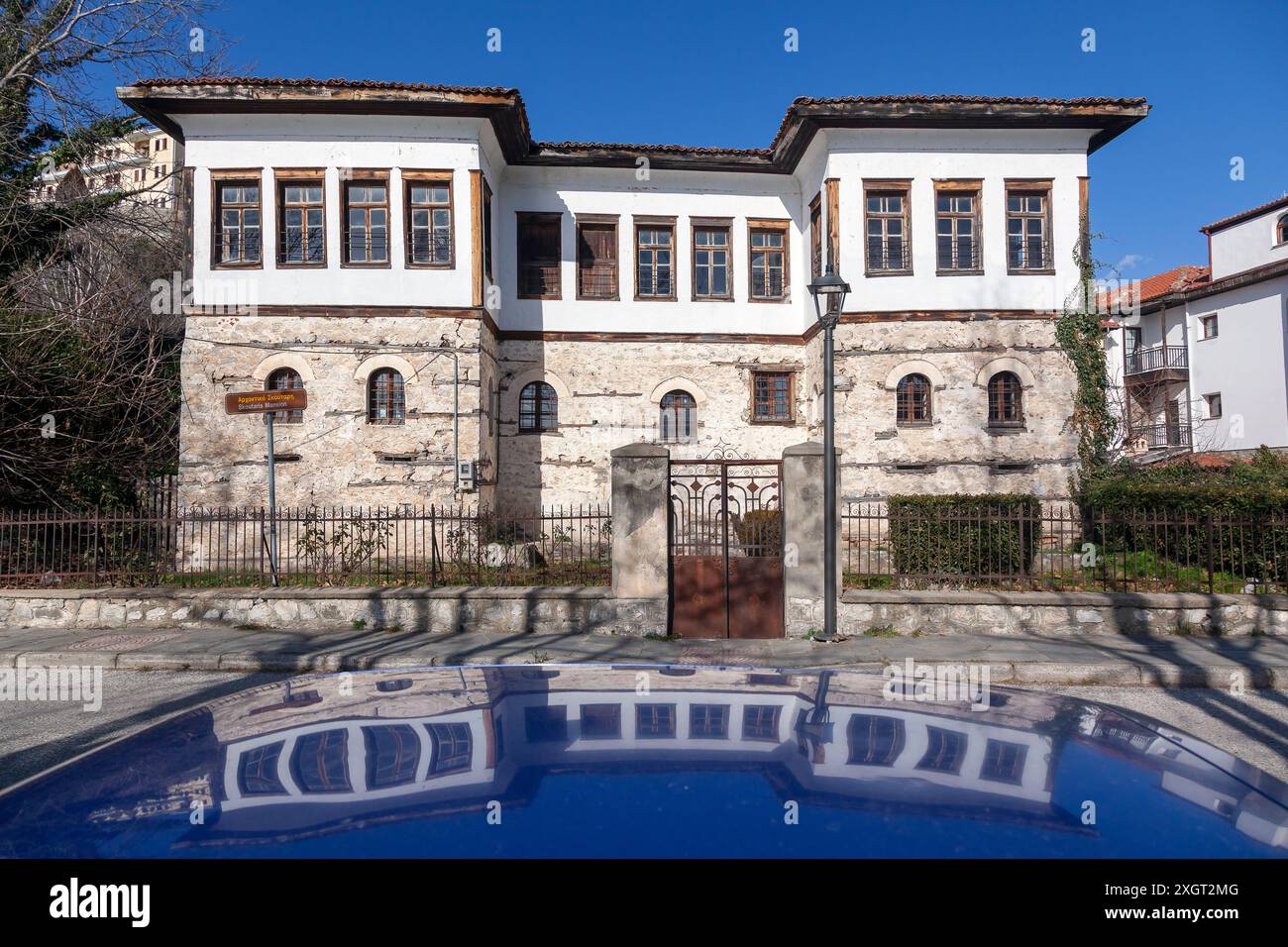 Manoir Skoutari reflété sur le toit d'une voiture, un joyau architectural à Kastoria, en Grèce, mettant en valeur le style distinctif des demeures locales traditionnelles Banque D'Images