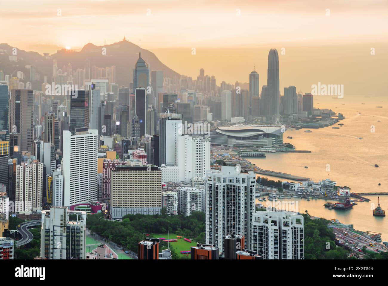 Belle vue sur l'île de Hong Kong et le port Victoria au coucher du soleil. Les gratte-ciel du centre-ville sont visibles sur fond de ciel orange. Paysage urbain pittoresque. Banque D'Images