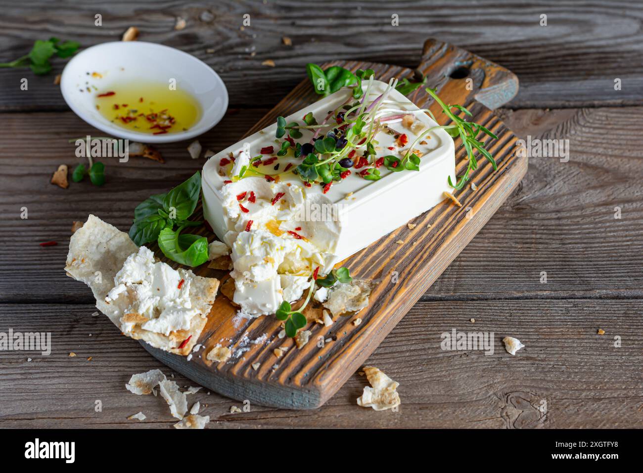 Un morceau de feta frais (paneer) avec des olives, des herbes, des épices et des tranches de pain plat (tortilla, lavash, pitta, chapatti) sur une planche en bois et un d Banque D'Images