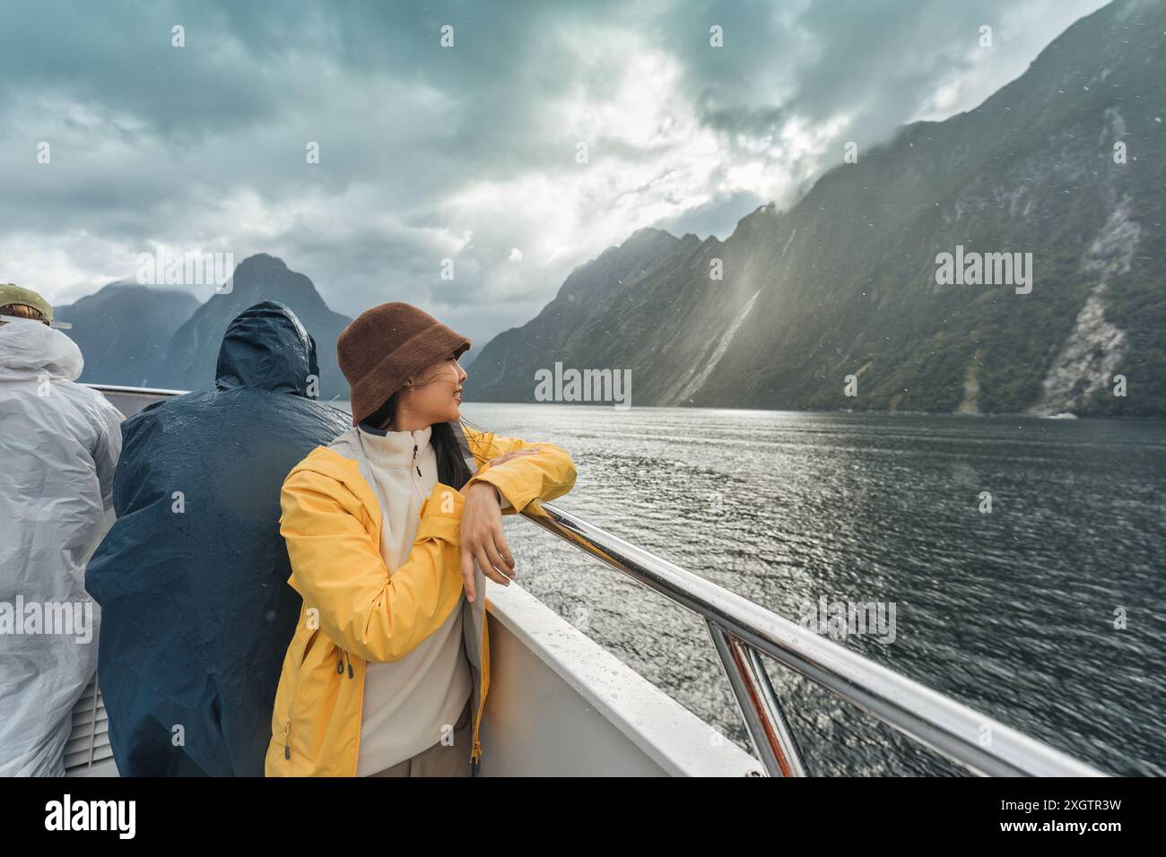 Jeune femme asiatique profitant de la vue de Milford Sound pendant la croisière en ferry dans le Fjord en vacances au parc national Fjordland, Nouvelle-Zélande Banque D'Images