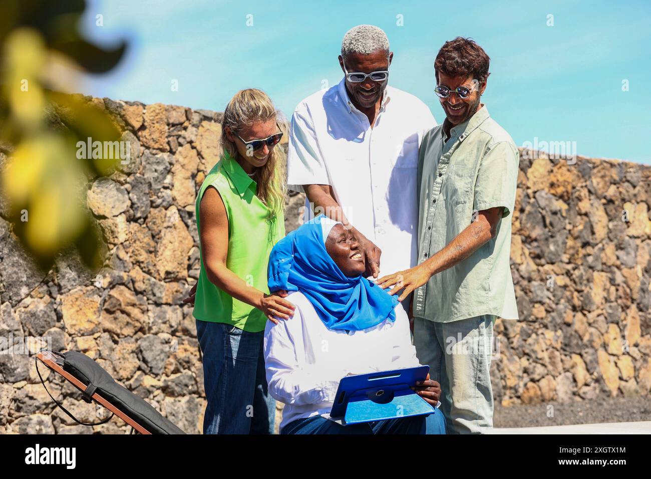 Un groupe multiethnique de quatre adultes, dont une africaine en hijab, un Afro-américain, une femme caucasienne et un hispanique, partagent une joie Banque D'Images