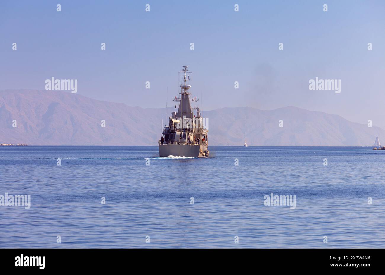 Un grand navire de guerre grec part patrouiller la frontière maritime avec la Turquie depuis la baie de l'île de Symi, en Grèce, au Dodécanèse Banque D'Images