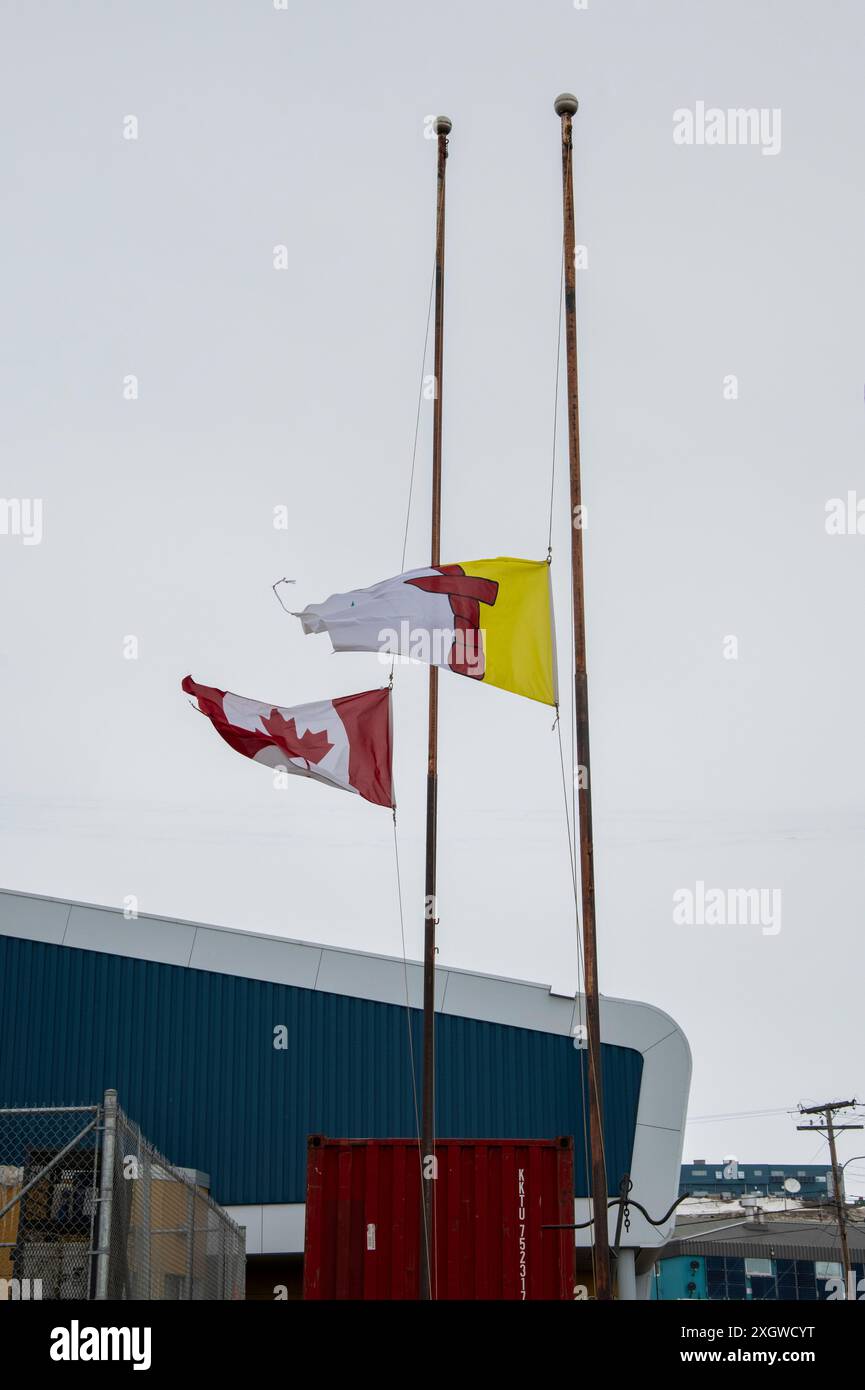 Drapeaux canadiens et territoriaux flottant à moitié personnel à Iqaluit, Nunavut, Canada Banque D'Images