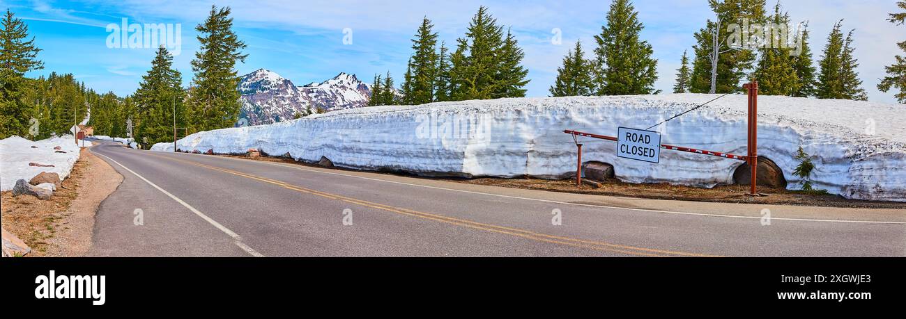 Route de montagne enneigée fermée signe en plein soleil d'hiver Banque D'Images