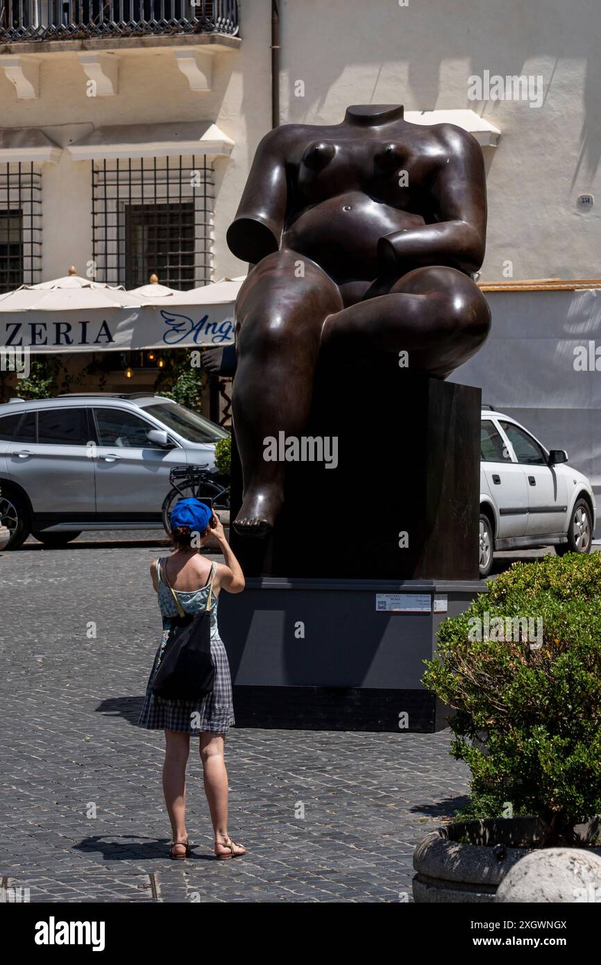 Tourist prend une photo en face de «femme assise» - une partie de «Botero a Roma» : un itinéraire d'exposition qui serpente dans les rues du centre-ville de Rome, combinant la beauté des œuvres de Fernando Botero avec la monumentalité de la capitale. La beauté contemporaine des sculptures de Fernando Botero complète le charme extraordinaire et unique de la capitale. L’exposition, qui s’étend sur quelques-unes des plus belles places du centre de Rome, permet de comparer deux mondes. Un hommage de la capitale au grand sculpteur colombien, récemment décédé, qui enrichit certains de ses plus R Banque D'Images