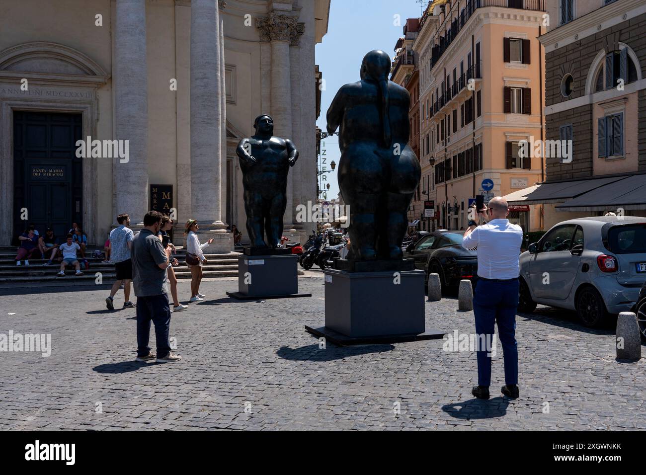 Les touristes prennent une photo devant «Adam (homme debout)» et «Eve (femme debout) - parties de «Botero a Roma» : un itinéraire d'exposition qui serpente dans les rues du centre-ville de Rome, combinant la beauté des œuvres de Fernando Botero avec la monumentalité de la capitale. La beauté contemporaine des sculptures de Fernando Botero complète le charme extraordinaire et unique de la capitale. L’exposition, qui s’étend sur quelques-unes des plus belles places du centre de Rome, permet de comparer deux mondes. Un hommage de la capitale au grand sculpteur colombien, récemment décédé, Banque D'Images
