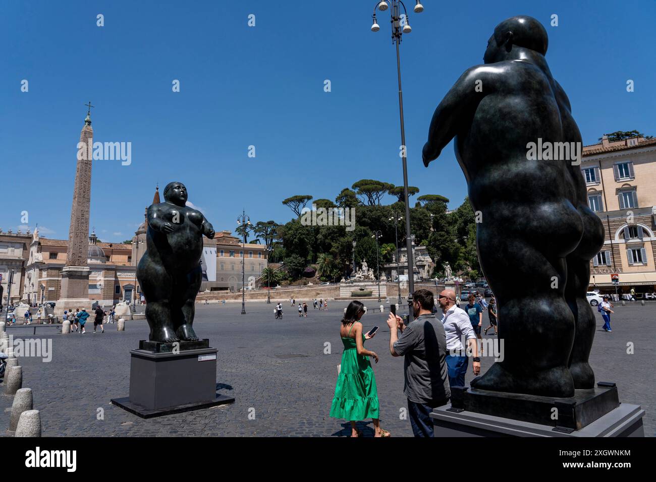 Les touristes prennent une photo devant «Adam (homme debout)» et «Eve (femme debout) - parties de «Botero a Roma» : un itinéraire d'exposition qui serpente dans les rues du centre-ville de Rome, combinant la beauté des œuvres de Fernando Botero avec la monumentalité de la capitale. La beauté contemporaine des sculptures de Fernando Botero complète le charme extraordinaire et unique de la capitale. L’exposition, qui s’étend sur quelques-unes des plus belles places du centre de Rome, permet de comparer deux mondes. Un hommage de la capitale au grand sculpteur colombien, récemment décédé, Banque D'Images
