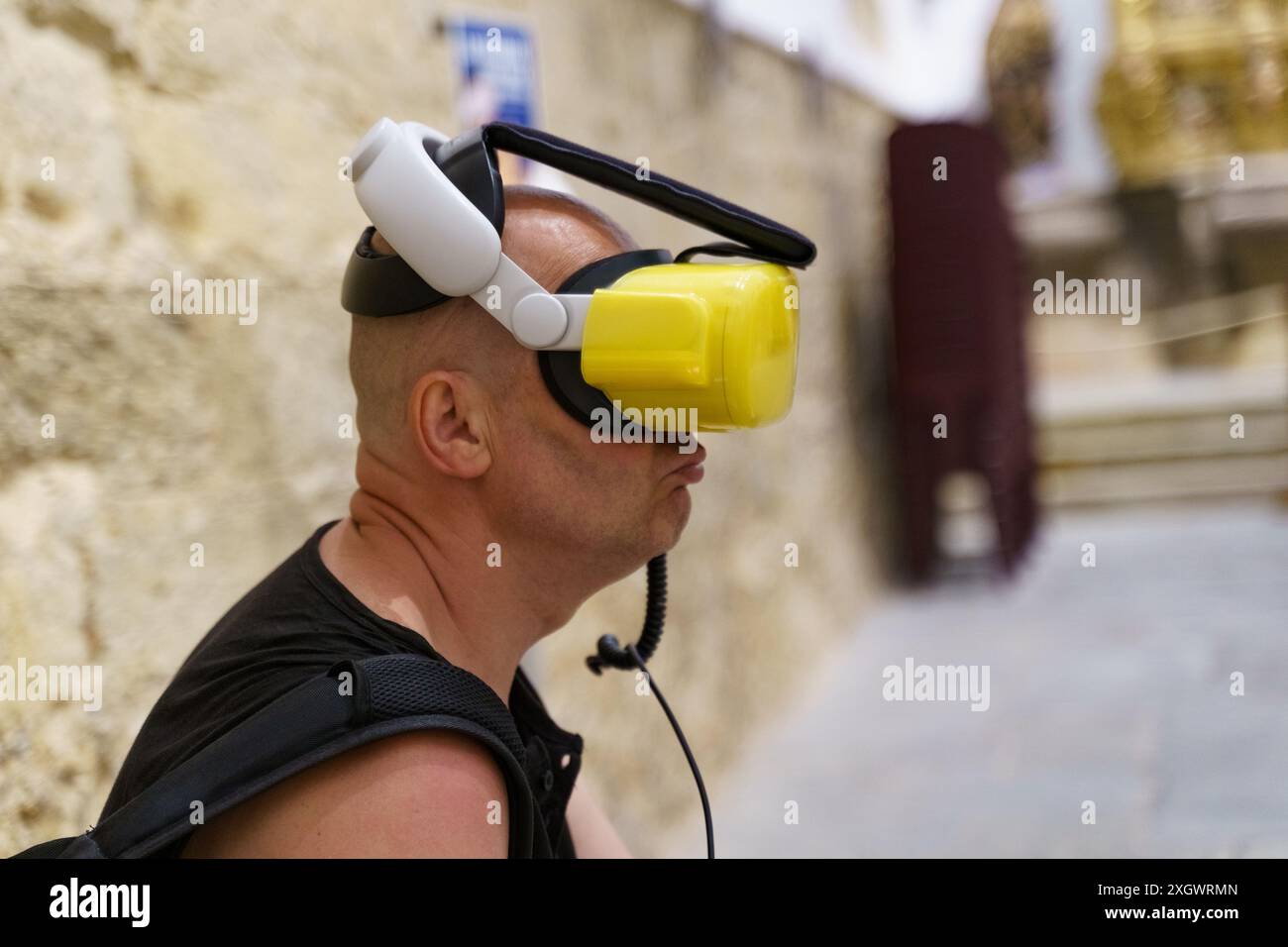 Astorga, Espagne - 4 juin 2023 : un homme portant un casque VR est assis dans un musée, expérimentant la réalité virtuelle. Le musée se trouve dans la cathédrale de Santa Mara Banque D'Images