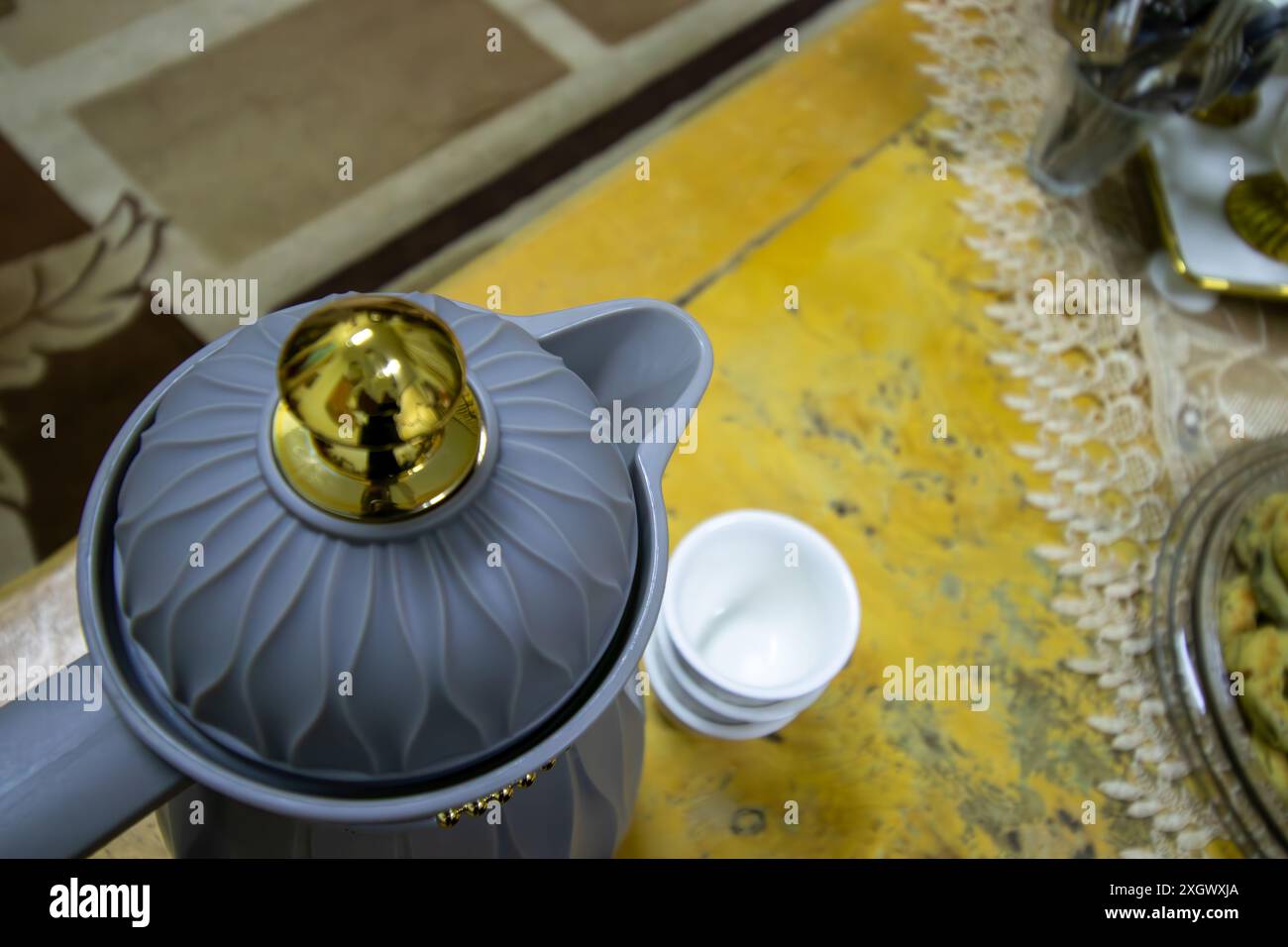 Vue de dessus pour la pointe de pot de café arabe et les bonbons eid avec des tasses en arrière-plan sur la table en bois Banque D'Images