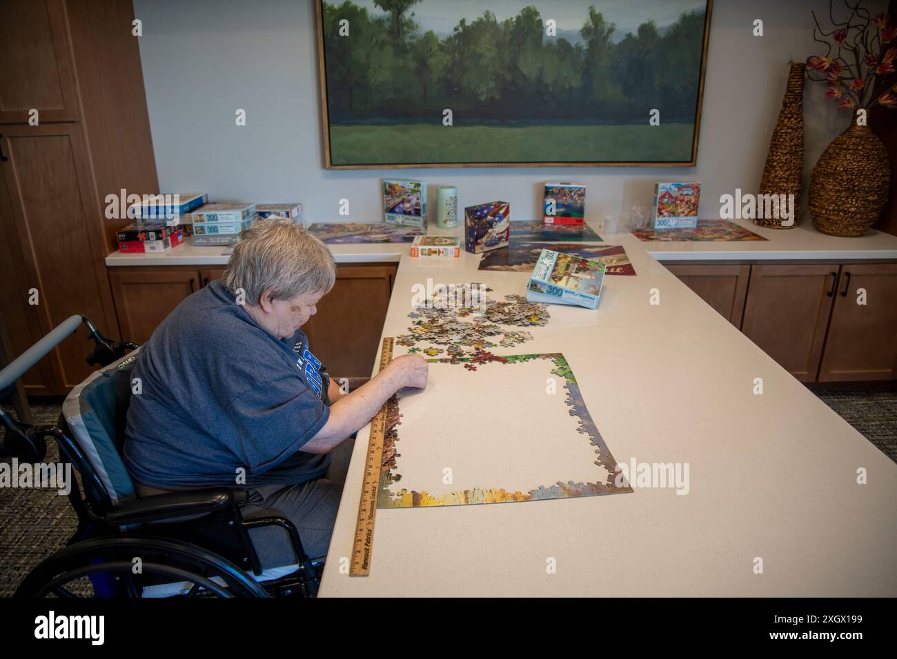 Maplewood, Minnesota. Femme âgée victime d'un accident vasculaire cérébral travaillant sur un puzzle dans la salle communautaire d'une maison de soins infirmiers. Banque D'Images