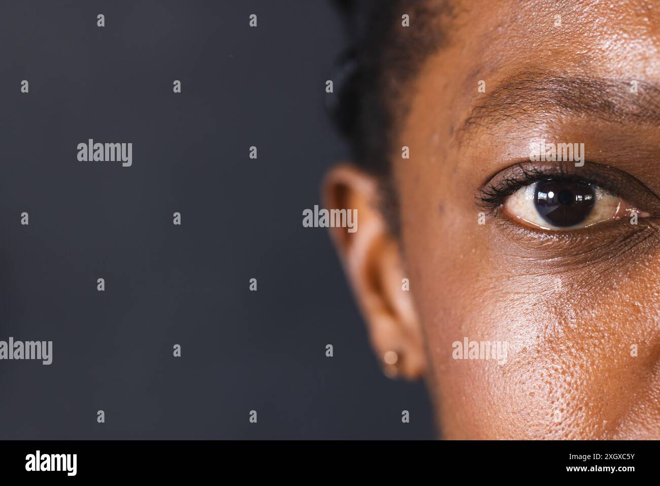 Gros plan de l'oeil d'une femme afro-américaine, avec espace de copie. Le détail capture la beauté et l'unicité des diverses caractéristiques faciales inaltérées. Banque D'Images