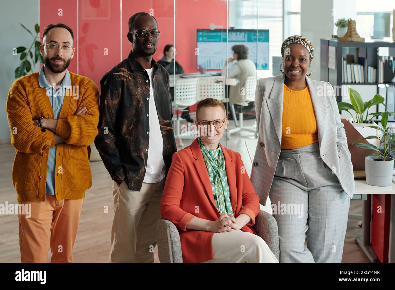 Portrait de quatre collègues divers posant au bureau, montrant confiance et professionnalisme. Les membres de l'équipe comprennent des personnes caucasiennes, noires et multiraciales, représentant l'inclusivité Banque D'Images